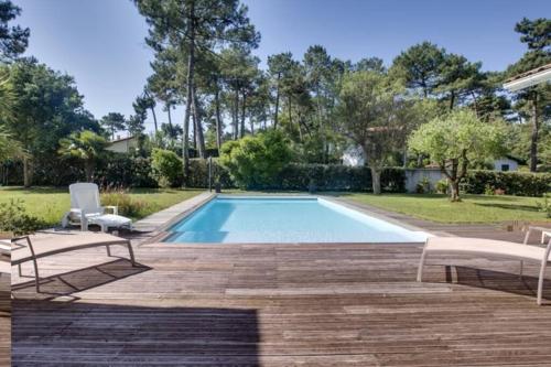 - une piscine avec un banc et une chaise dans l'établissement Villa Alaska - climatisée 10 personnes avec piscine chauffée, à Seignosse