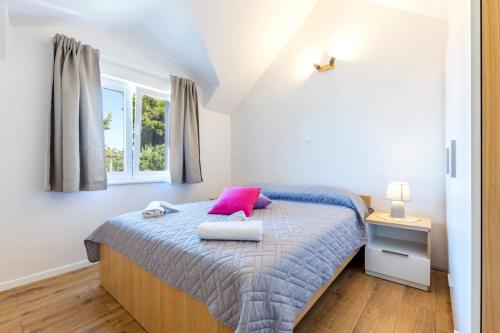 um quarto com uma cama com uma almofada cor-de-rosa em Balkun em Maslinica
