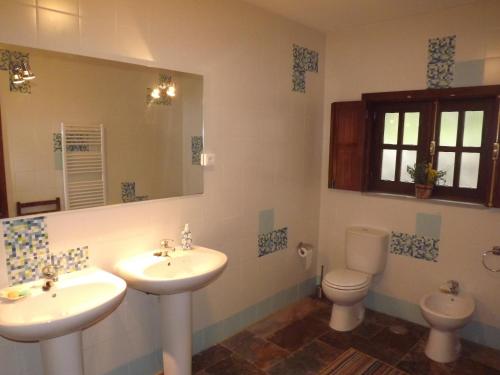 a bathroom with two sinks and a toilet at Casa Oliveiras do Douro in Sobreira