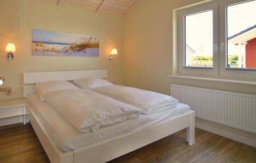 ein weißes Bett in einem Zimmer mit 2 Fenstern in der Unterkunft Amazing Home In Dagebll With Wifi in Dagebüll