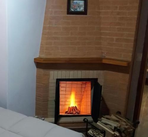 a brick fireplace with a fire in it at Chales Mãe e Filho in Monte Verde