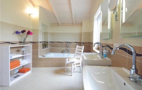ein Badezimmer mit einer Badewanne und einem Waschbecken in der Unterkunft Ferienhaus K�stenweg E in Dagebüll