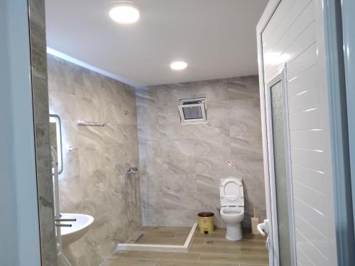 a bathroom with a toilet and a sink at Condo Rooms in Sarandë