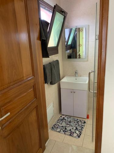 a small bathroom with a sink and a mirror at Appartement chic et moderne in Douala