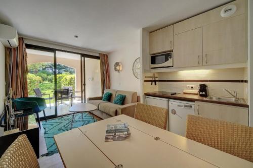 une cuisine et un salon avec une table et des chaises dans l'établissement IMMOGROOM - 2 Rooms - Renovated - Pool - AC - Parking - Garden, à Cannes