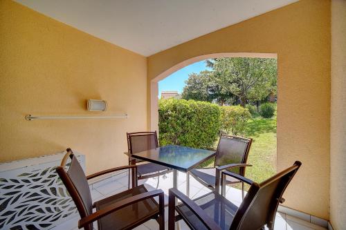 une table en verre et des chaises sur un balcon dans l'établissement IMMOGROOM - 2 Rooms - Renovated - Pool - AC - Parking - Garden, à Cannes