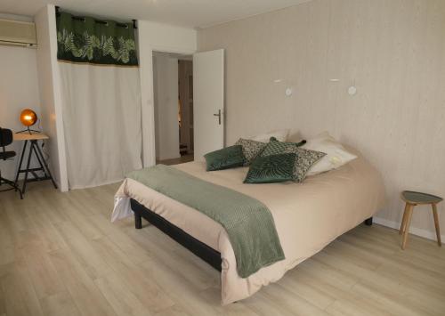 Un dormitorio con una cama grande con almohadas. en Iaorana en Claveyson