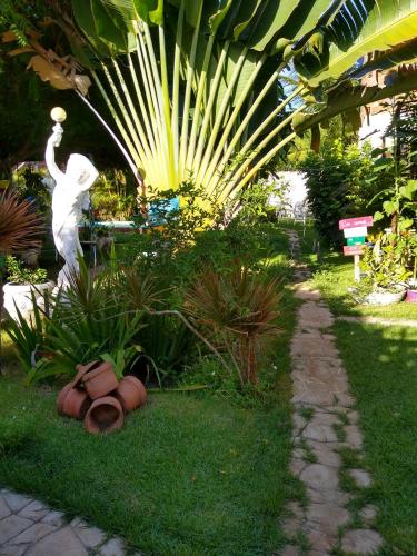 a statue of a person throwing a ball in a garden at Pousada São Miguel Filosofal in São Miguel do Gostoso