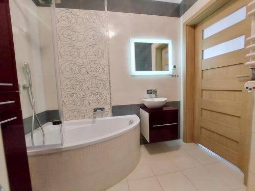 a bathroom with a tub and a sink at Apartament Ania in Świnoujście