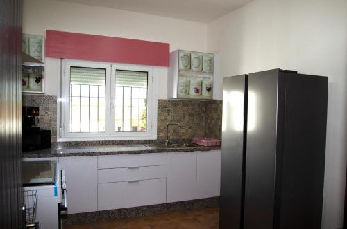 a kitchen with a stainless steel refrigerator and a window at Zapata Home in Alhaurín de la Torre