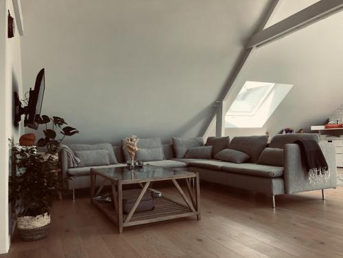 ein Wohnzimmer mit einem Sofa und einem Tisch in der Unterkunft Lichtrijke loft bij restaurant Den Olifant in Ypern