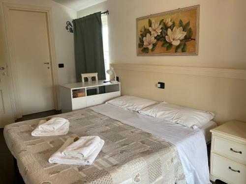 a bedroom with a bed with two towels on it at Villa La Baia a pochi passi dal lago in San Felice del Benaco