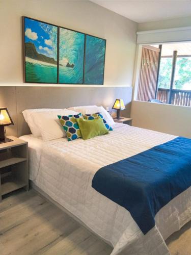 a bedroom with a large bed with a blue blanket at POUSADA ATALAIA NORONHA in Fernando de Noronha