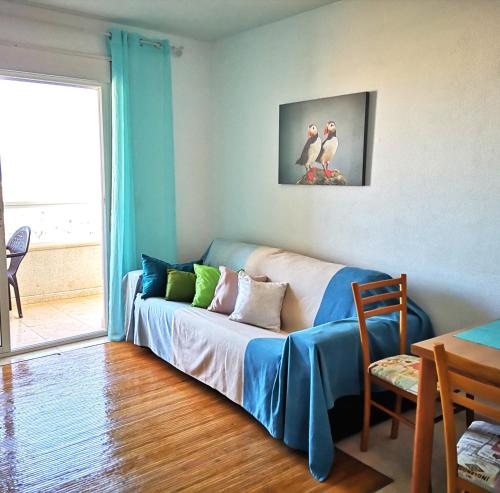 ein Wohnzimmer mit einem Sofa mit zwei Vögeln darauf in der Unterkunft Alta Vista - apartamento con 2 dormitorios y vista al mar in Torrevieja