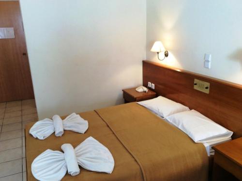 a hotel room with a bed with white pillows at Andreolas Beach Hotel in Laganas