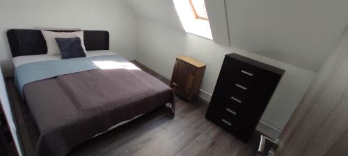Tímár Apartman Eger في إغير: غرفة نوم صغيرة مع سرير وخزانة
