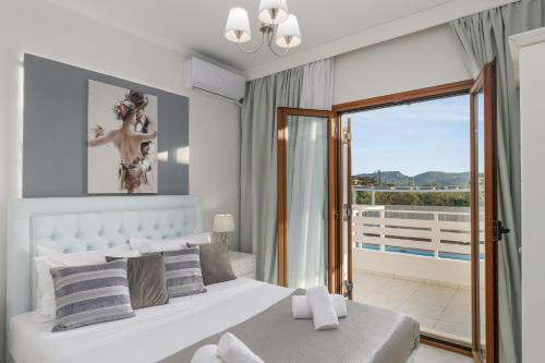 a bedroom with a bed and a view of a balcony at Villla Eva Milos in Adamas