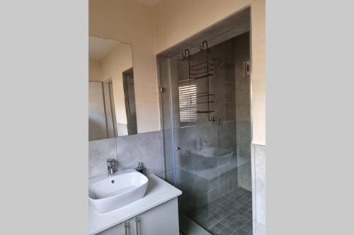 ein Badezimmer mit einem Waschbecken, einer Badewanne und einer Dusche in der Unterkunft Koena Court (Unit 2) - With Uncapped Fiber Wi-Fi in Midrand