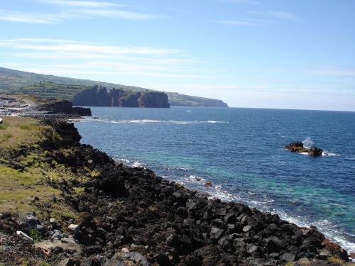 a view of the ocean from a rocky shore at Hotel Vale Do Navio in Capelas