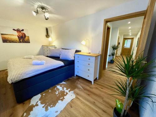 Schlafzimmer mit einem Bett, einer Kommode und einem Spiegel in der Unterkunft FeWo Zeitlos in Berchtesgaden