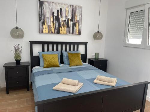 Un dormitorio con una cama azul con dos almohadas. en UIM Mediterraneo CASA Plomo Wifi, en Puerto Sagunto