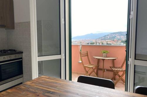 a kitchen with a table and chairs and a balcony at Borgio Verezzi, Mare, Natura e Relax in Borgio Verezzi