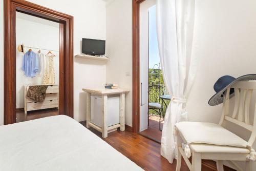 サンタ・テレーザ・ガッルーラにあるCasa Gallassoのベッドルーム(ベッド1台、椅子1脚、バルコニー付)