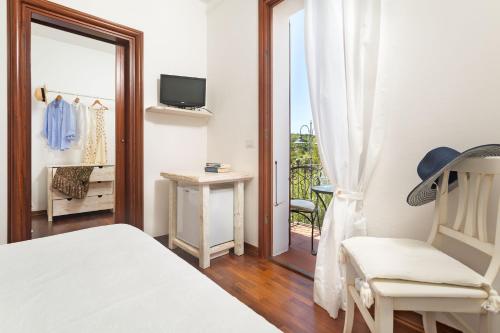a bedroom with a bed and a chair and a balcony at Casa Gallasso in Santa Teresa Gallura