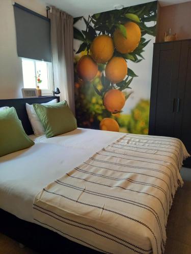 a bedroom with a bed with a painting of oranges at Os Mundos in Deurne