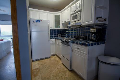 a kitchen with white cabinets and a white refrigerator at Shore View Hotel in Hollywood