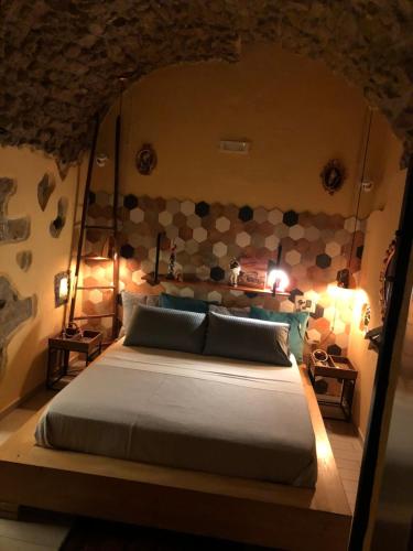 - une chambre avec un grand lit et un mur en pierre dans l'établissement Donna Margherita Appartamento, à Naples