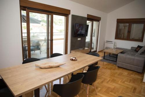a dining room with a wooden table and chairs at Penthouse with Old bridge view and jacuzzi in Mostar