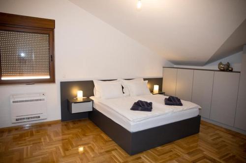 a bedroom with a bed with two candles on it at Penthouse with Old bridge view and jacuzzi in Mostar