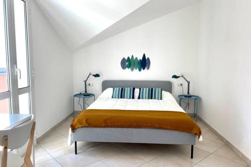 1 dormitorio con 1 cama con 2 mesas y 2 lámparas en Terrazza Vista Mare, en Borgio Verezzi