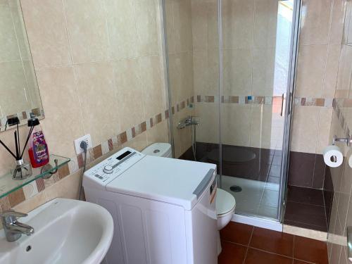 a bathroom with a toilet and a sink and a shower at Vista Playa in Mogán