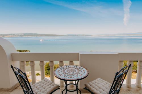 einen Tisch und Stühle auf einem Balkon mit Meerblick in der Unterkunft Hotel Miramare in Crikvenica