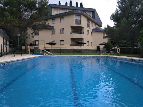 a large blue swimming pool in front of a building at Tena Biescas Tourist Home in Biescas