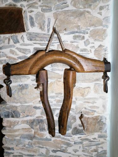 a wooden antler rack hanging on a stone wall at La Chouette in Pieve di Teco