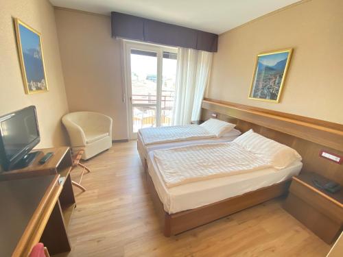a hotel room with a bed and a television at SunLake Hotel in Riva del Garda