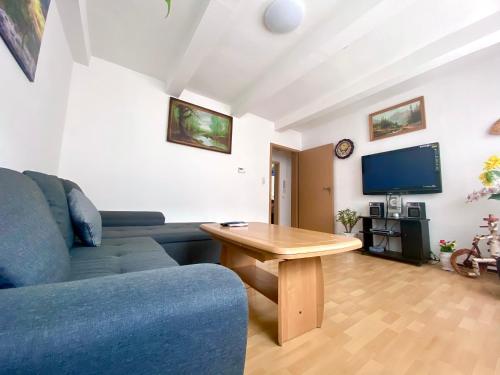 uma sala de estar com um sofá azul e uma mesa de madeira em Fewo im Herzen von Wernigerode 2 em Wernigerode