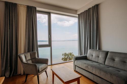 a living room with a couch and a large window at Hotel Miramare in Crikvenica