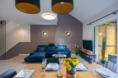 a living room with a blue couch and a table at Apartamenty Pod Stokiem 200 m do kolejki Na Skrzyczne - Dream Apart in Szczyrk