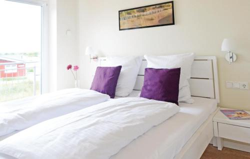1 Schlafzimmer mit 2 weißen Betten und lila Kissen in der Unterkunft Gorgeous Home In Dagebll With Kitchen in Dagebüll