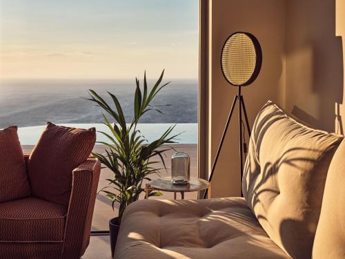 Una sala de estar con un sofá y vista al mar. en Etheria Luxury Villas & Suites, en Agios Nikolaos