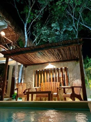 a group of chairs and a table next to a pool at La Selva Apartments Tulum in Tulum