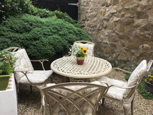 a table and two chairs and a table with a flower pot on it at Peaseblossom House, a charming Grade II Listed Building, in a great location in Alnwick in Alnwick