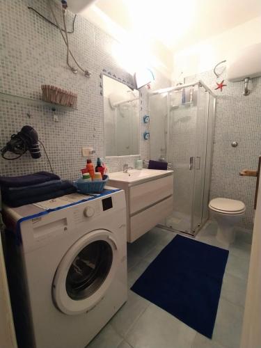 a bathroom with a washing machine and a sink at Via Marina 19 - Casa sul mare. in Buggerru