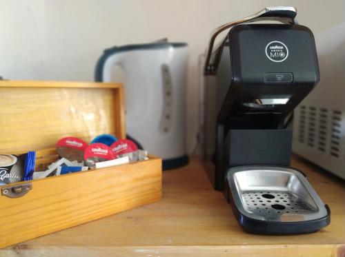 a coffee maker sitting on a table with a box at Via Marina 19 - Casa sul mare. in Buggerru