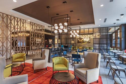 lobby restauracji z krzesłami i stołami w obiekcie Hotel Indigo Tulsa DWTN/Entertainment Area w mieście Tulsa