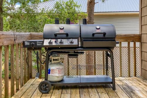 a grill sitting on top of a wooden deck at Coronado Cove Cottage in Dauphin Island